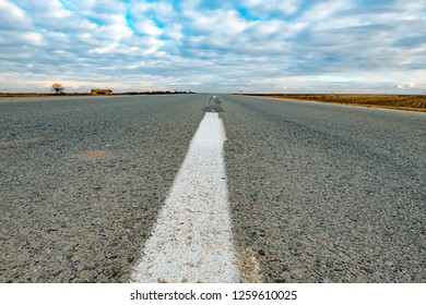 Low angle view of empty road through countryside on cold winter day without snow