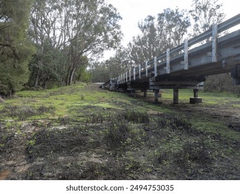 Low angle view of the end of an old bridge with green vegetation. - Powered by Shutterstock