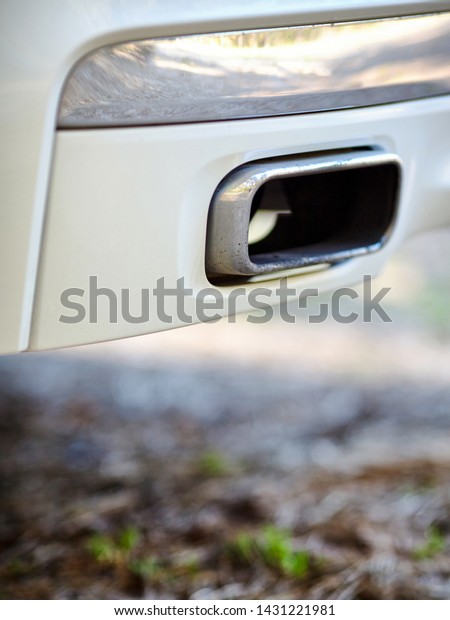 Low angle view of the exhaust pipe of a car\
with selective focus on tailpipe vertical. Concept of greenhouse\
effect and air pollution due to carbon monoxide and dioxide\
emissions from fuel\
combustion.