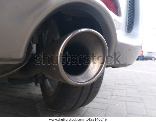 Low angle view of the exhaust pipe of a car with\
selective focus to the tailpipe. Close-up car exhaust pipe. exhaust\
pipe of family car. 