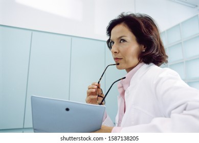 Low Angle View Of A Female Doctor Looking At A Clipboard