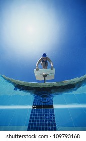 Low Angle View Of Female Swimmer Ready To Dive In Water