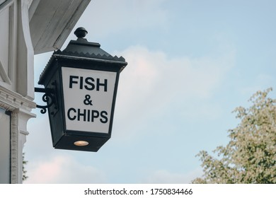 Low angle view of Fish and Chip sign outside a restaurant in London, UK, against the sky, copy space.
