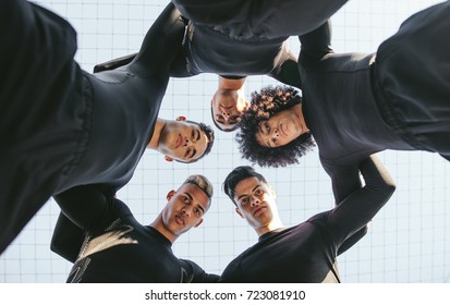 Low Angle View Of Five A Side Football Team Huddle. Young Soccer Player Standing In A Circle.