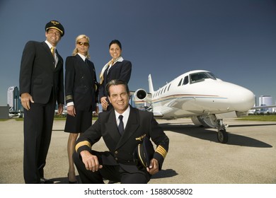 Low Angle View Of Flight Crew Standing Next To Airplane On Tarmac