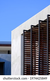 Low Angle View Of Folding Metal Sunshade Battens On Loft Cement Wall Of Modern Building Against Blue Sky In Vertical Frame