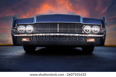 Low angle view of front grill of a vintage car  with a dramatic sky
