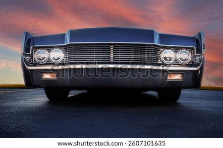 Low angle view of front grill of a vintage car  with a dramatic sky