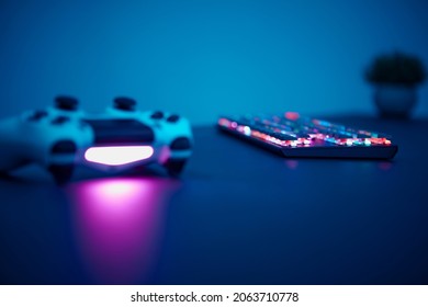 Low angle view of gaming controller and keyboard laying on table. Low light scene. Professional computer game playing, esport business and online world concept. - Powered by Shutterstock - Get 15% off with code: PIKWIZARD15
