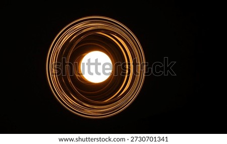 Low angle view of a glowing round light bulb inside a ribbed glass fixture creating golden concentric circles against a pitch-black background. This abstract minimalist composition represents innovation, bright ideas, focused energy, and modern interior design. Perfect for use as a dramatic wallpaper or conceptual backdrop.