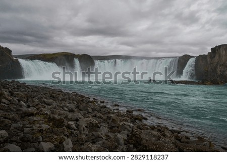 Low angle view of Godafoss waterfall from rocky shoreline - North Iceland
