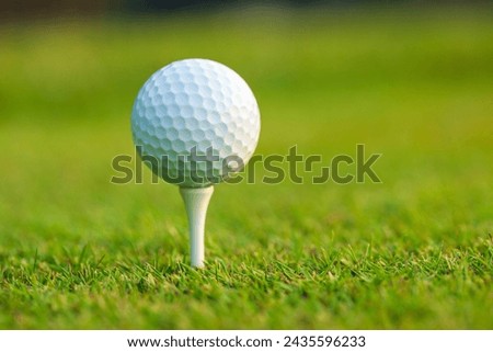 Low angle view of a golf ball on a tee in front of defocused background