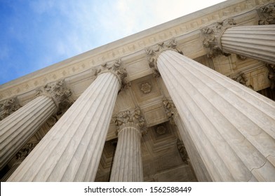 Low angle view of grand classical stone columns soaring up to decorative entablature at a Court building in Washington DC, USA