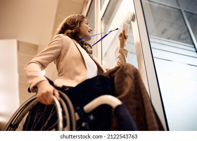 Low Angle View Of Happy Businesswoman With Disability Using Card Key To Unlock Office Door.