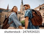 Low angle view of view of happy couple of tourists walking in the town.