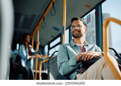Vista de ángulo bajo de un hombre feliz montando en un bus. Copiar espacio. 