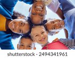 Low angle view of happy mixed race children embracing each other while smiling at camera. Cute little group of schoolchildren sticking heads together. Closeup face of girls and little boys embracing.