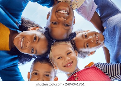 Low angle view of happy mixed race children embracing each other while smiling at camera. Cute little group of schoolchildren sticking heads together. Closeup face of girls and little boys embracing. - Powered by Shutterstock