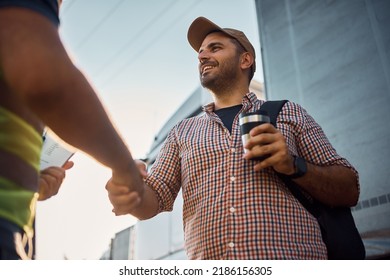 Low angle view of happy truck driver and freight transportation manager greeting on parking lot.  - Shutterstock ID 2186156305