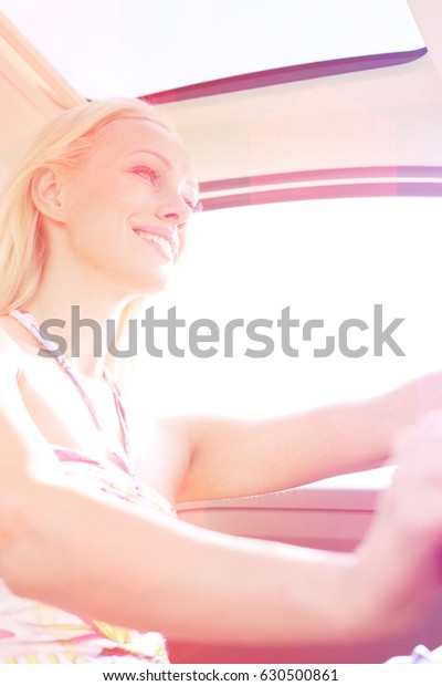 Low angle view of\
happy woman driving car