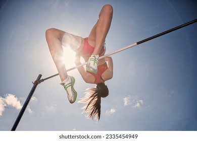 Low angle view high jumper clearing bar - Powered by Shutterstock