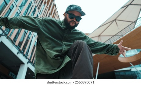 Low angle view of hipster pose in hip hop style surrounded by mall view. Portrait of sporty asian hip hop choreographer dancing break dance while looking at camera. Outdoor sport 2024. Hiphop. - Powered by Shutterstock