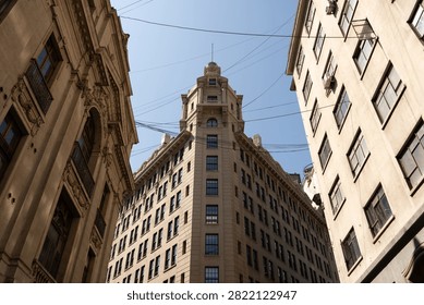 Low angle view of historic Edificio Ariztia building facade between classic structures under clear blue sky in Santiago Chile
