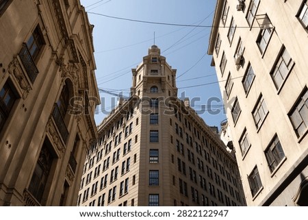 Low angle view of historic Edificio Ariztia building facade between classic structures under clear blue sky in Santiago Chile