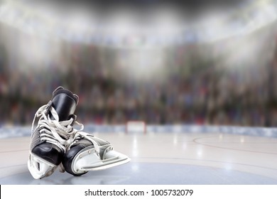 Low angle view of hockey skates on ice with deliberate shallow depth of field on brightly lit stadium background and copy space.