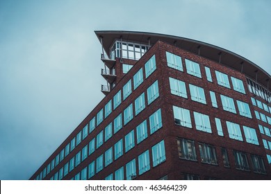 Low angle view of housing with segmented top floor and skirt roof constructed with brick exterior