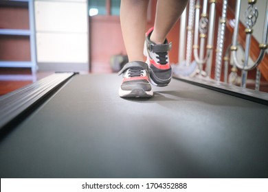 Low Angle View Of Human Feet Wearing Sport Shoes Running On Electric Treadmill At Home