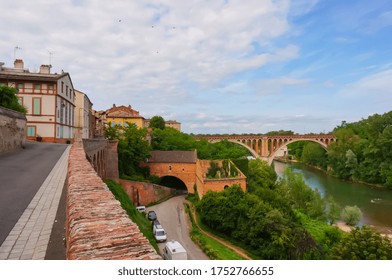 Low angle view of the imposing 700-year-old brick church of Notre-Dame du Bourg, a medieval Southern Gothic UNESCO World Heritage Site in Rabastens, France, featuring a rosette and a Romanesque portal