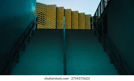 Low angle view of imposing brutalist concrete stairs leading to a geometric modern building.