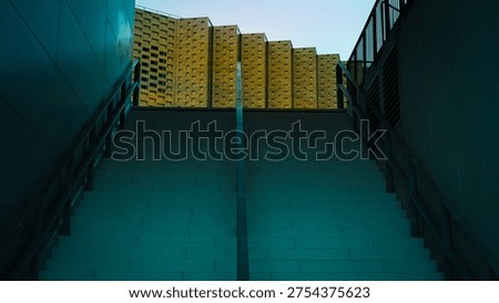 Low angle view of imposing brutalist concrete stairs leading to a geometric modern building.