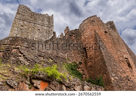 Low angle view of the imposing stone walls of medieval Goodrich Castle ruins, England