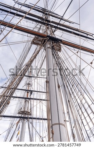 Low angle view of the intricate rigging and wooden masts of a classic sailing ship.