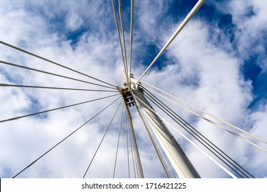 Low angle view looking directly upwards at bridge supports against a cloudy sky