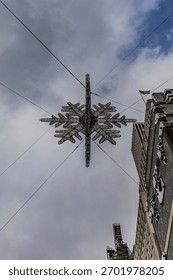 A low angle view looking up at the giant star hanging over the intersection of 57th Street and Fifth Avenue in NYC on a cloudy day.