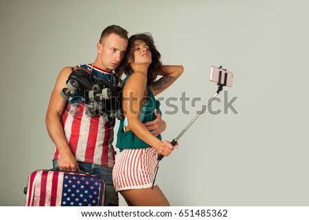 Low angle view of loving young couple on summer vacation taking a self portrait with smartphone outdoors. Couple in love. Tourist couple. Love story. Happy family. Sexy girl. Sensual concept. Fashion