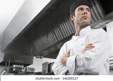 Low Angle View Of A Male Chef With Arms Crossed In Kitchen