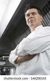 Low Angle View Of A Male Chef With Arms Crossed In Kitchen