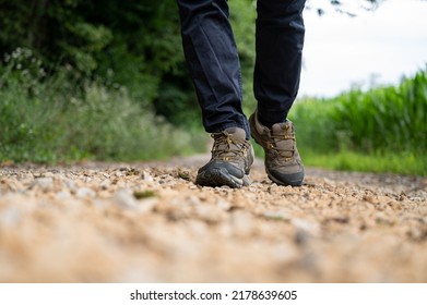 Low Angle View Of Male Legs In Hiking Shoes Walking On A Trail.