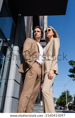 Similar – Image, Stock Photo Low angle of Fashion black female entrepreneur in smart casual looking away while standing against building