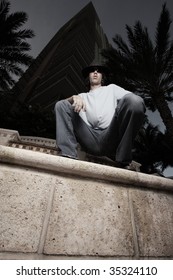 Low angle view of a man squatting on a ledge