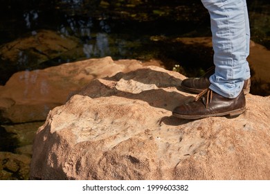 Low angle view of man standing on the rocky cliff, travel concept
