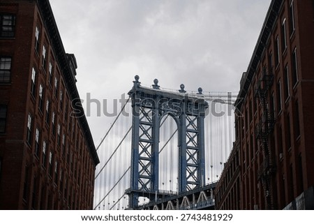 Low angle view of Manhattan Bridge between brick buildings in Brooklyn