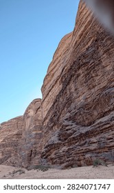 Low angle view of massive sandstone rock formations and cliff walls in Wadi Rum desert, Jordan
