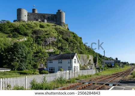 Low angle view of medieval fortification Harlech Castle in Harlech, Gwynedd, Wales, UK built on a rocky knoll by Edward I during his invasion of Wales along railroad tracks