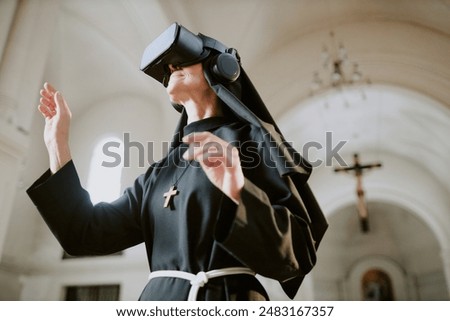 Low angle view medium shot of senior Caucasian nun standing inside Catholic cathedral building using VR technologies for education