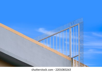 Low angle view of metal spike fence on rooftop of tenement building for security concept - Shutterstock ID 2201083263